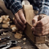 Un uomo sta lavorando su un pezzo di legno.